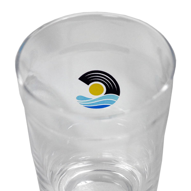 A drink cup made of clear glass, featuring a logo with a sun and waves design in blue and yellow.
