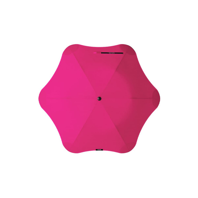 A pink BLUNT Metro Umbrella with a unique shape and a central button for opening and closing.