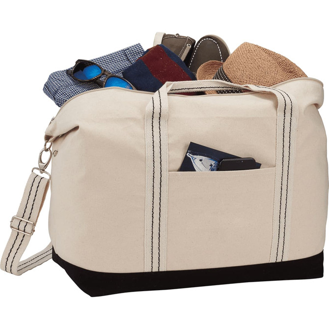 A cream and black cotton canvas duffel bag filled with assorted clothing items and accessories. It has a logo.