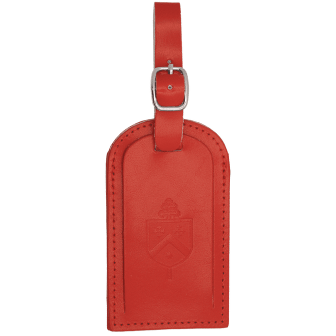 A red luggage tag featuring a decorative design and a buckle for attachment. It has a branded logo.