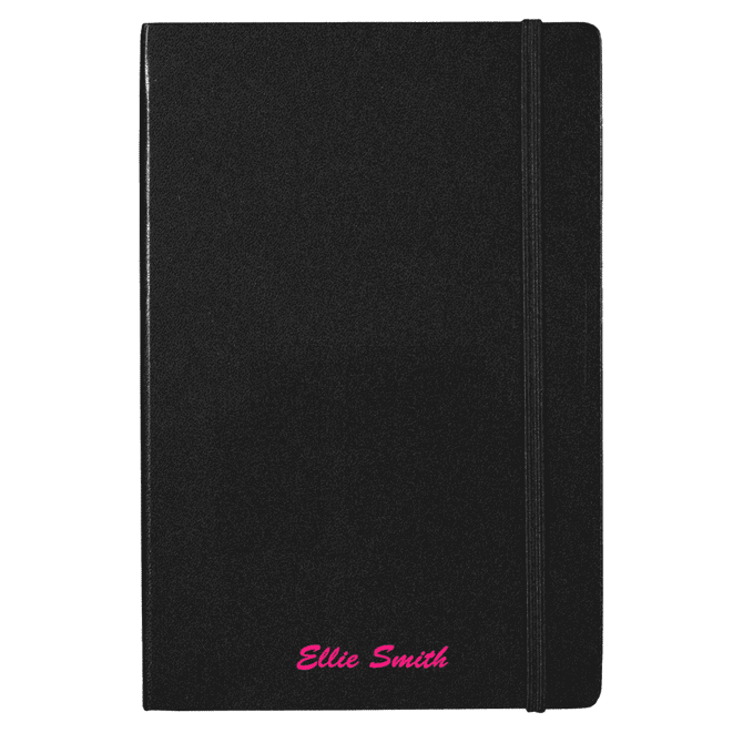 A black journal with an elastic band, featuring a custom name in pink text at the bottom. It includes a branding logo.