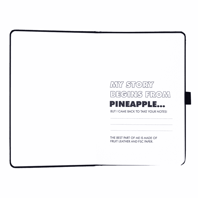 A pineapple leather bound journal with blank pages, featuring a black cover and an interior with printed text.