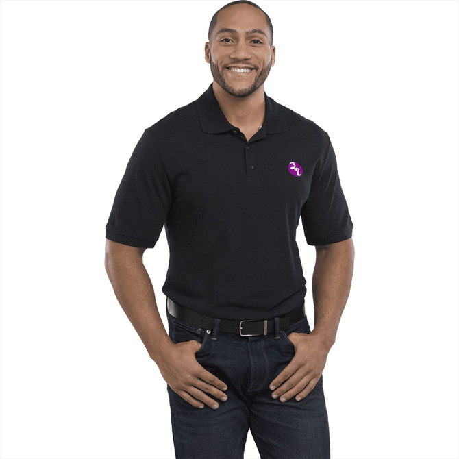 A man wearing a black short sleeve polo shirt with a logo on the chest, styled with jeans and a belt.