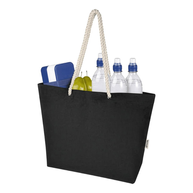A black tote bag with a rope handle, filled with water bottles, a blue cooler, and green fruit. It features a logo.