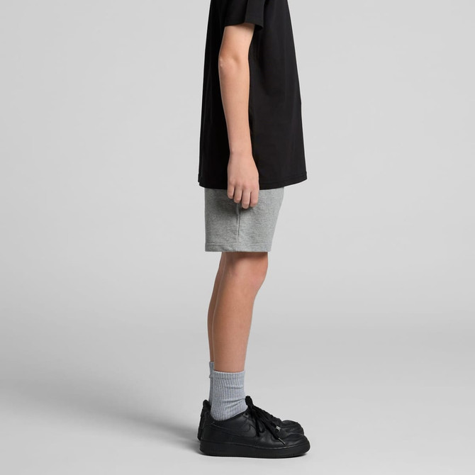 Youth stadium shorts in grey, worn with a black t-shirt and black sneakers, shown from the side.