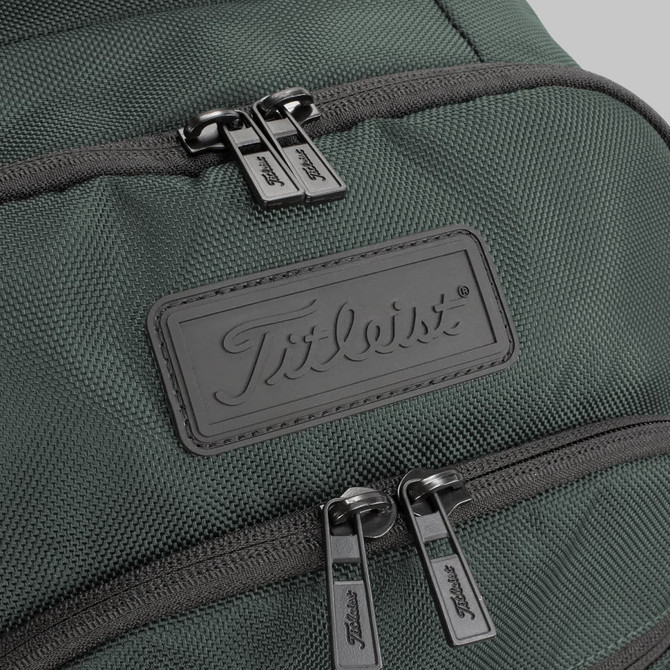 A green backpack featuring two zippered compartments and a branding logo on the front.