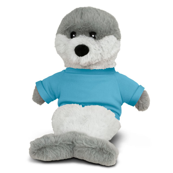 A plush seal toy with a grey and white body, wearing a blue T-shirt. It has a logo on its shirt.