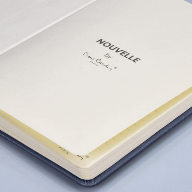 A blue notebook with a hard cover, featuring lined pages and a logo on the inside cover.