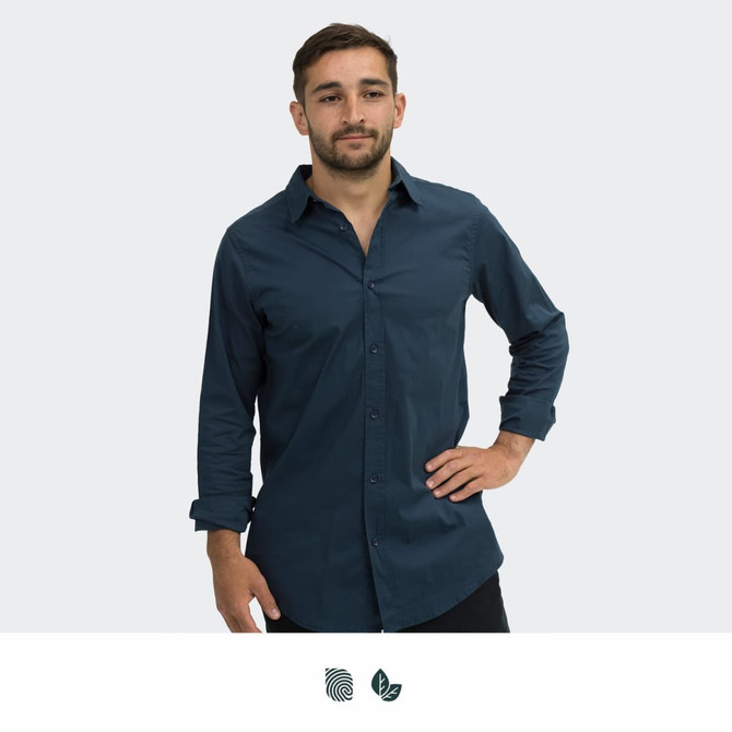 A navy blue button-up shirt worn by a man with a relaxed posture and long sleeves. The shirt features a logo.