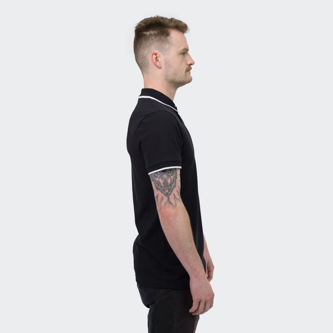 A black polo shirt with contrasting white accents, featuring a logo, showcased on a male model from the side.
