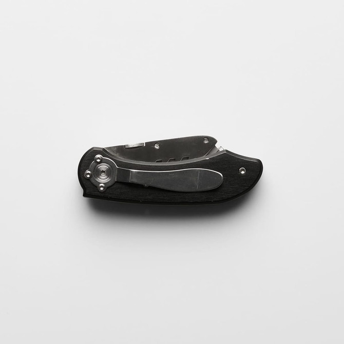 A black and silver utility knife with a folding design and a metallic finish, featuring a logo.