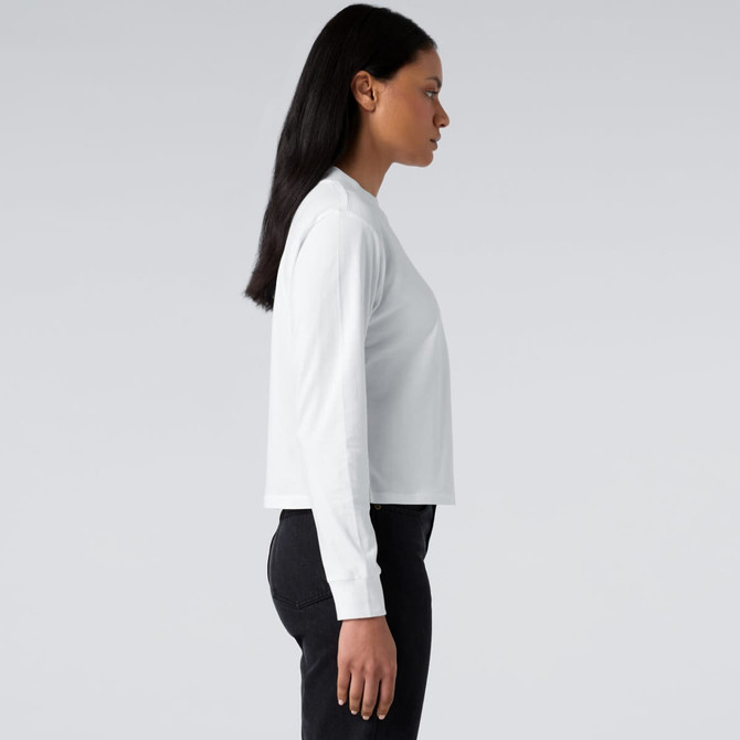 A long-sleeve white tee in a side view, featuring a relaxed fit and a logo on the chest.
