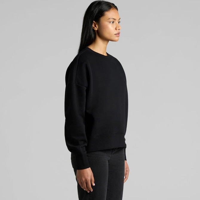 A black crew jumper with a relaxed fit, displayed on a model from the side. The garment features a subtle logo.