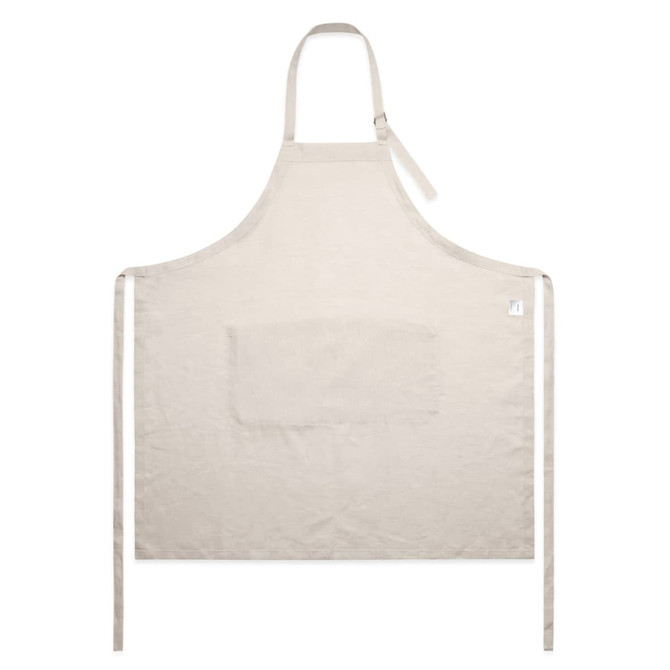 A beige linen apron featuring a front pocket and ties for securing. Includes a logo on the side.