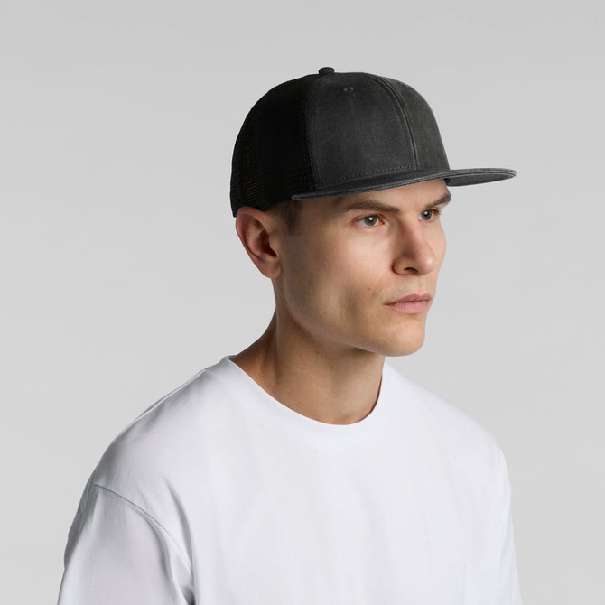 A grey faded trucker cap with a flat brim, featuring a logo, worn by a model in a white t-shirt.