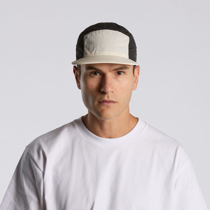 A two-tone nylon cap featuring a light-coloured front panel and a black back, with a logo on the front.
