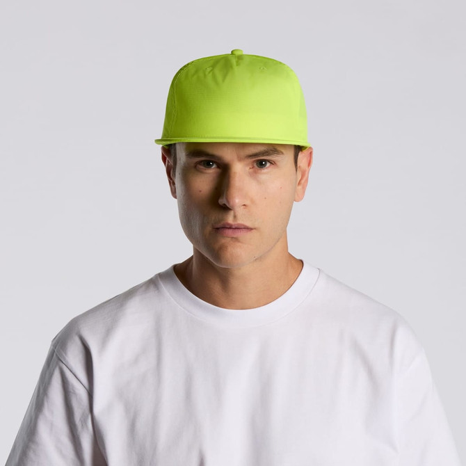 A bright yellow cap with a flat brim, worn by a person in a white t-shirt. The cap features a logo.