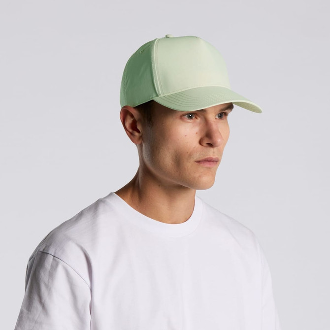 A light green nylon cap worn by a person, featuring a structured design and a logo on the front.