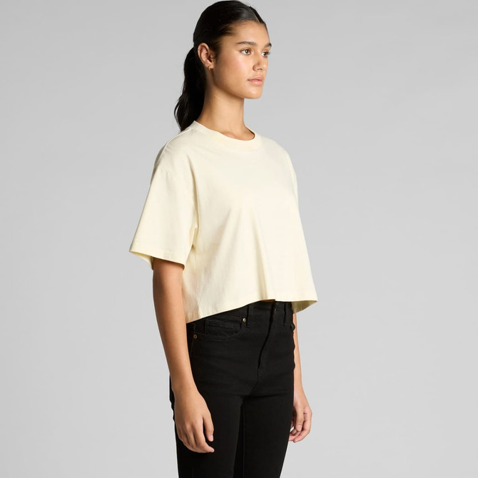 A cropped tee in a soft yellow colour, featuring a relaxed fit and short sleeves. It has a small logo on the front.