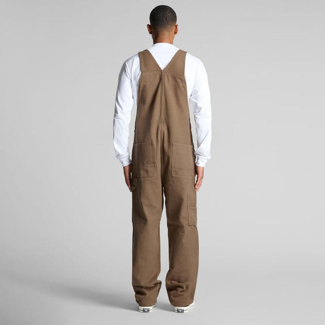 Canvas overalls in brown, featuring a simple design and a logo, viewed from the back on a model.