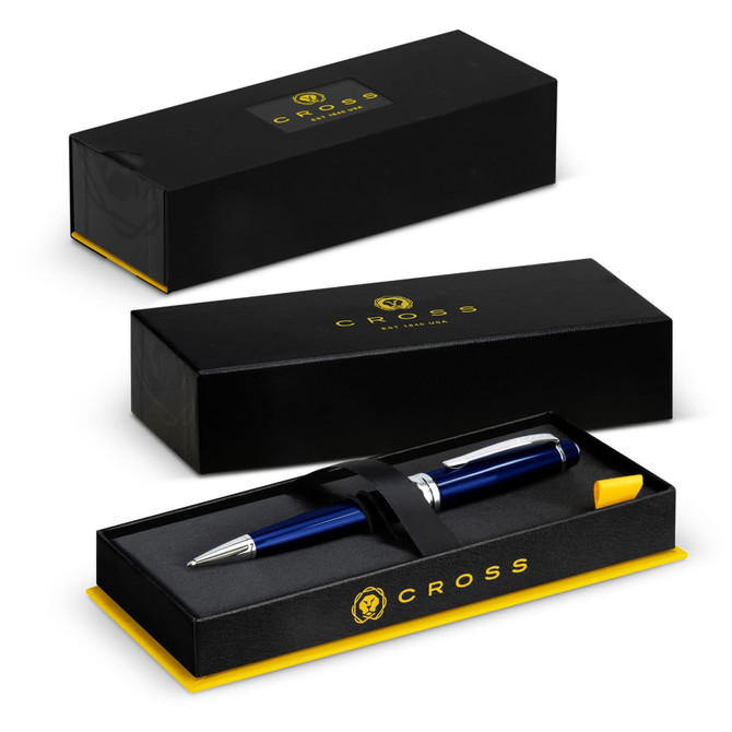 A Cross Bailey ballpoint pen in a black and gold box, featuring a navy blue pen secured with a black strap.