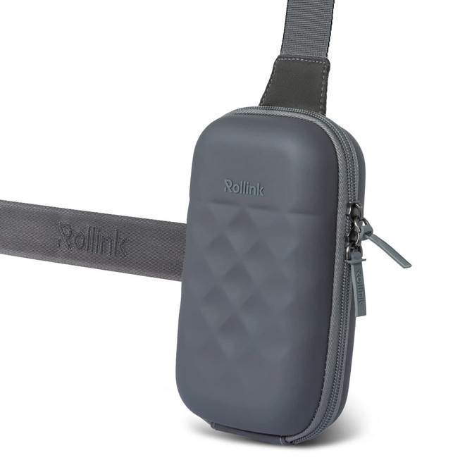 A grey Rollink Mini Bag Go featuring a textured surface and an adjustable strap. It includes a zip closure and logo branding.
