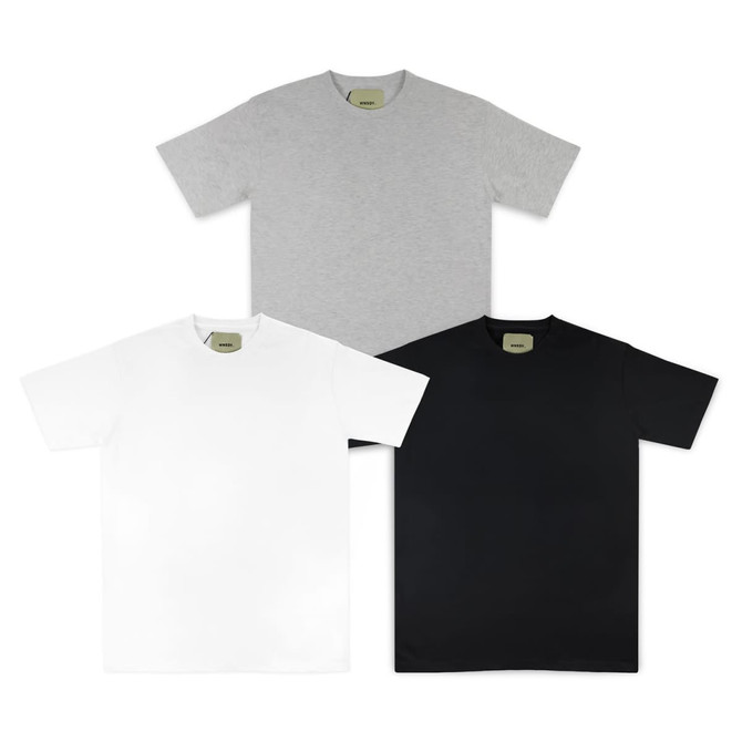 A set of three essential tees in grey, white, and black, each with a tag featuring a logo.