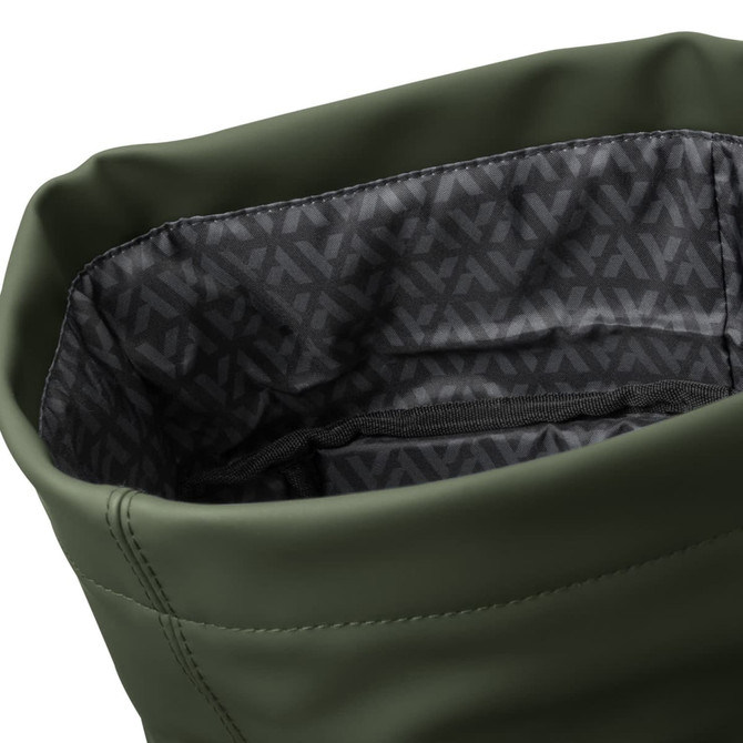 A soft-touch, olive green flap backpack with a patterned black interior and a zippered pocket inside.