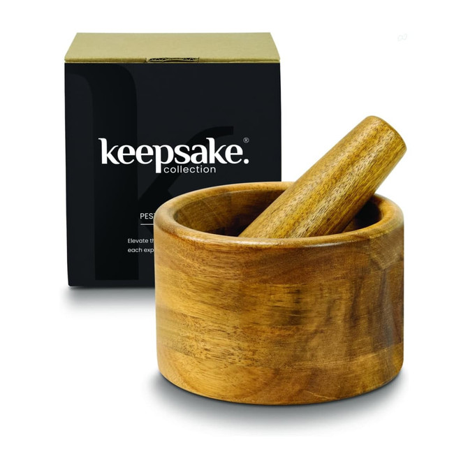 A wooden mortar and pestle set in a round bowl, displayed with a black box featuring a logo.