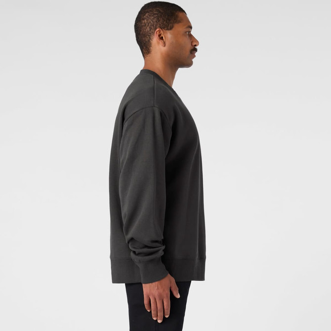 A dark grey jumper featuring a simple design, displayed on a model from the side. The jumper has a logo on it.