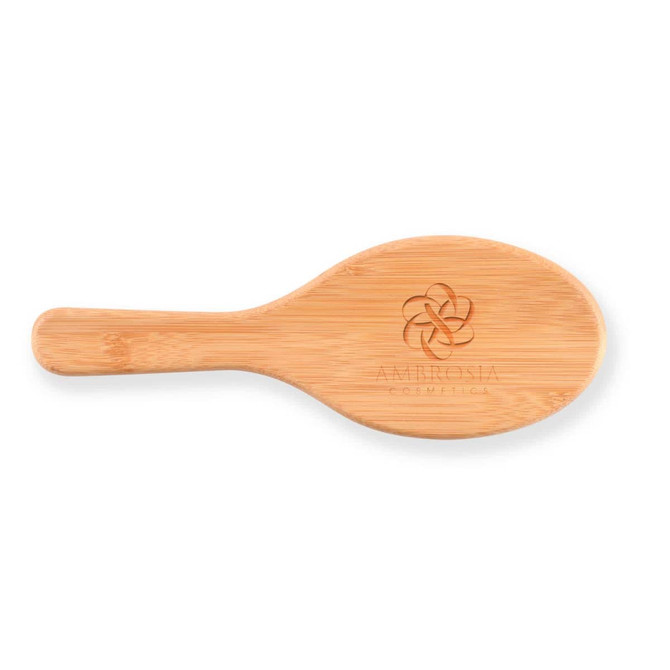 A bamboo hair brush with an engraved logo on the handle.