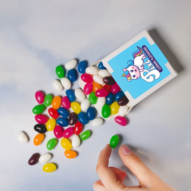An assortment of jelly beans in various colours, scattered around a box with a logo.