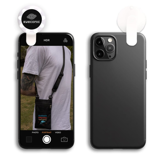 A black smartphone is displayed with an attached LED selfie light. The phone has a photo of a person wearing a bag.