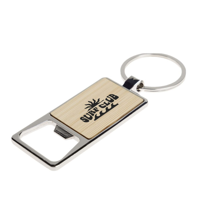 A drink bottle opener keytag with a stainless steel base and a wooden inlay featuring a sun design.