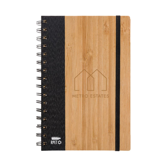 A spiral-bound notebook with a bamboo cover and a dark fabric section, featuring a logo.