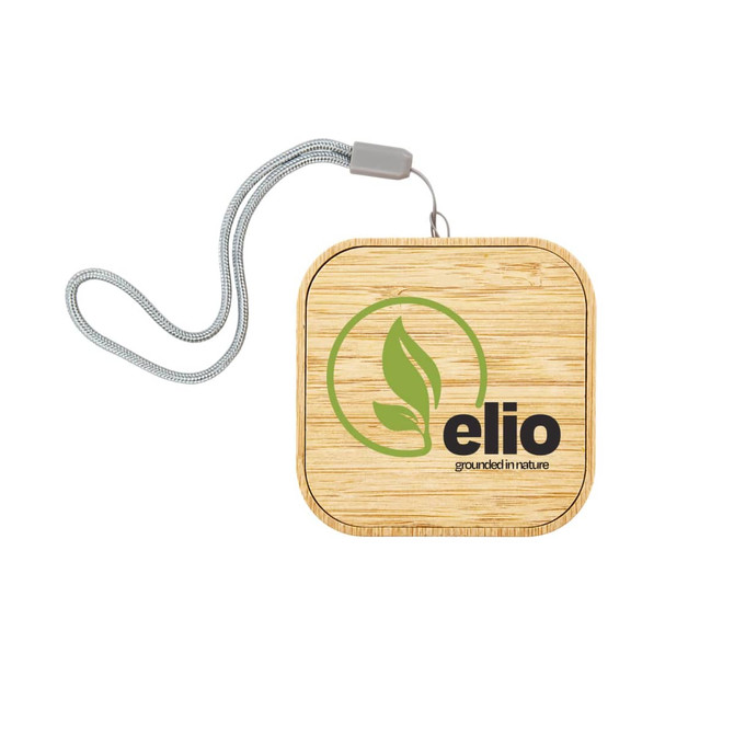 A square wireless charger in bamboo with a logo and a woven strap for easy carrying.