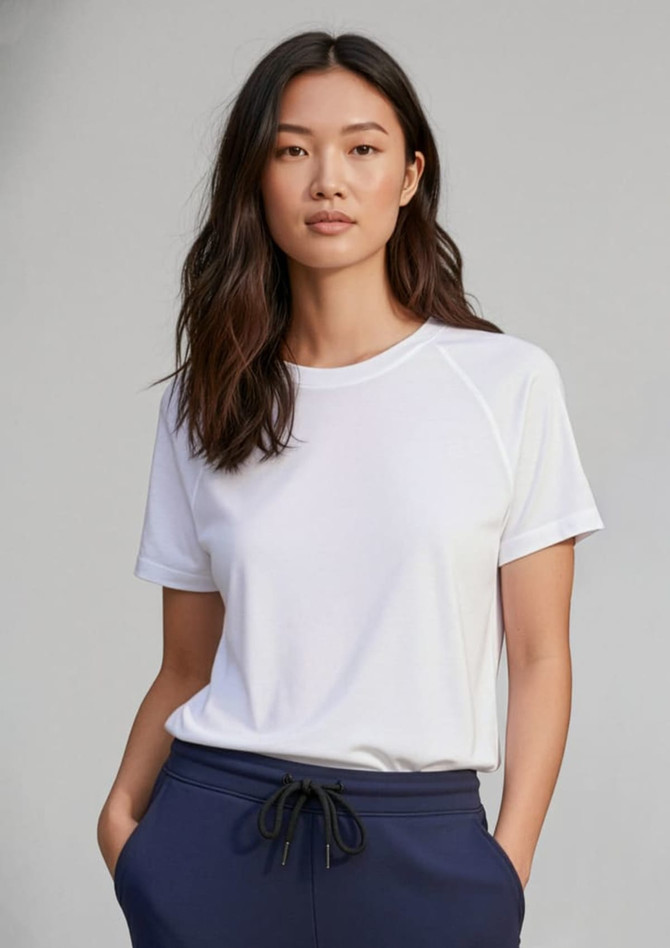 A white short sleeve tee with a relaxed fit, featuring a logo and styled with navy blue bottoms.