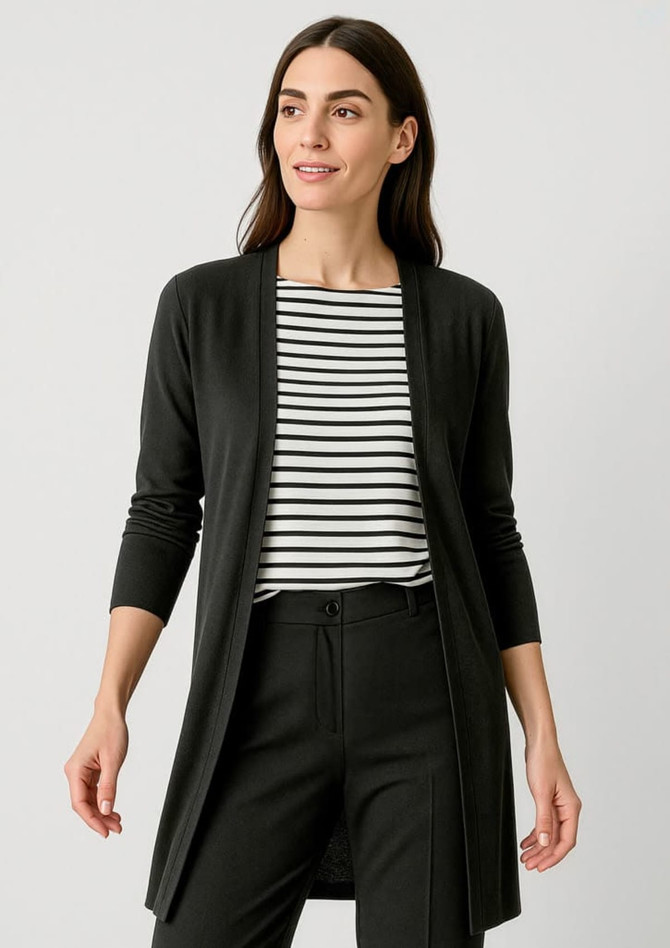 A longline cardigan in black, featuring a sleek design and open front. The model wears it over a striped top and black pants.