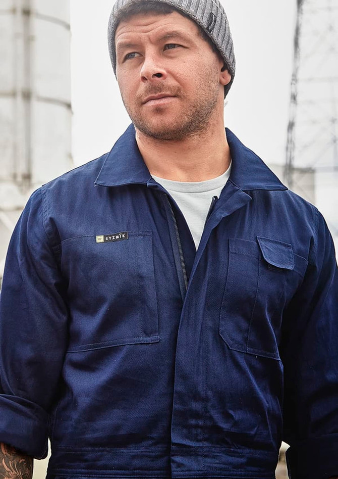 Navy lightweight cotton drill overall worn by a man, featuring a pocket and a logo on the chest.