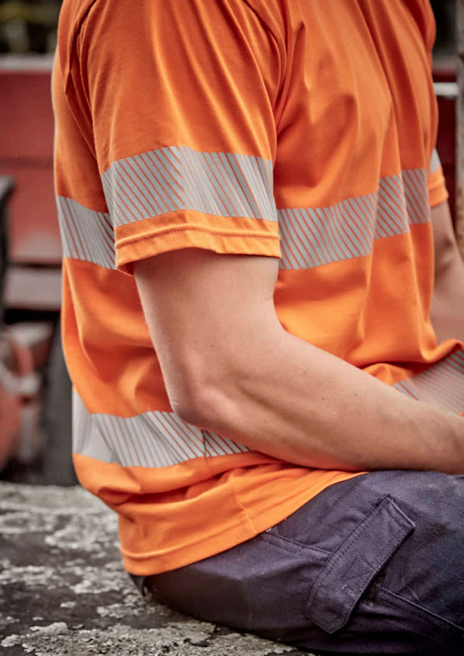 A men's short-sleeve hi-vis orange cotton tee with segmented reflective tape on the sleeves, featuring a relaxed fit.