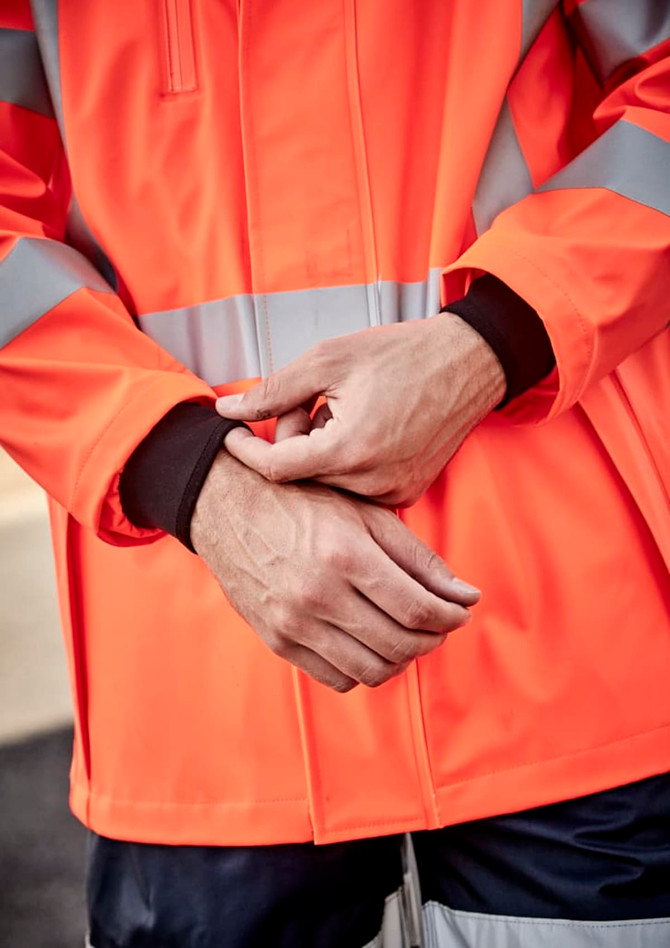 A heavy-duty waterproof jacket in bright orange with reflective stripes, featuring black cuffs. There is a logo on the jacket.
