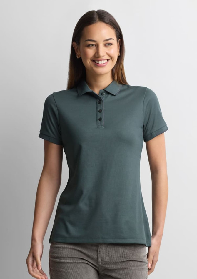 A women's short sleeve polo shirt in deep green, featuring a buttoned placket and fitted design. It has a logo.