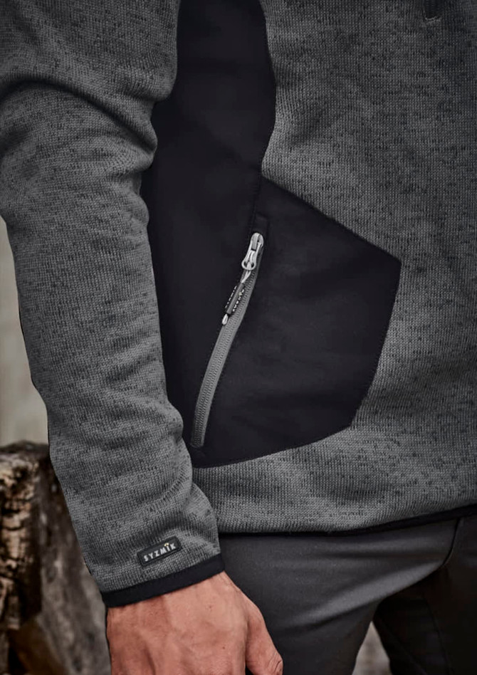A grey and black unisex pullover featuring a zippered pocket and a logo on the sleeve.