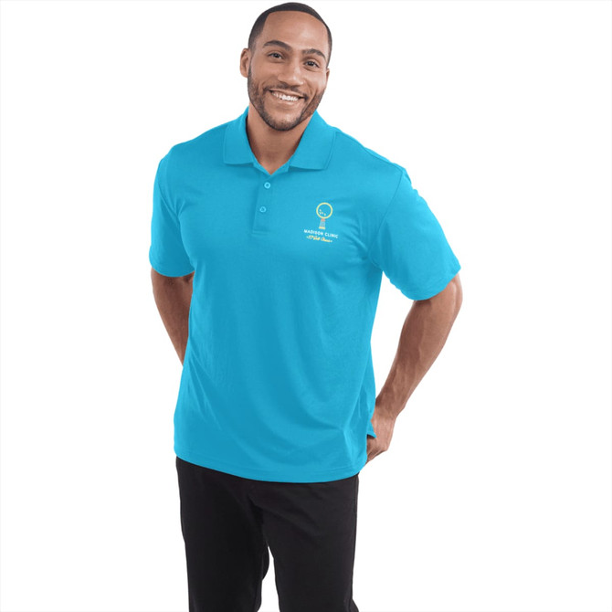 A turquoise polo shirt for men, featuring a collar and a logo on the chest, modelled by a smiling man.