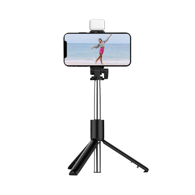 A black LED selfie stand with a smartphone mounted, featuring a light on top and adjustable tripod legs.