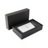 A grey and white wireless power bank in a black box with foam padding. It has a logo on the surface.