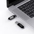 A silver Olympia LED flash drive is plugged into a laptop's USB port, with another flash drive beside it.