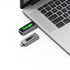 A USB flash drive in black and grey connecting to a laptop, featuring a logo and LED lights.
