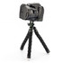 A black camera mounted on a flexible tripod with black foam grip legs and white rubber feet.