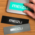 Three glossy paper stickers in black, grey, and teal, featuring placeholder branding.